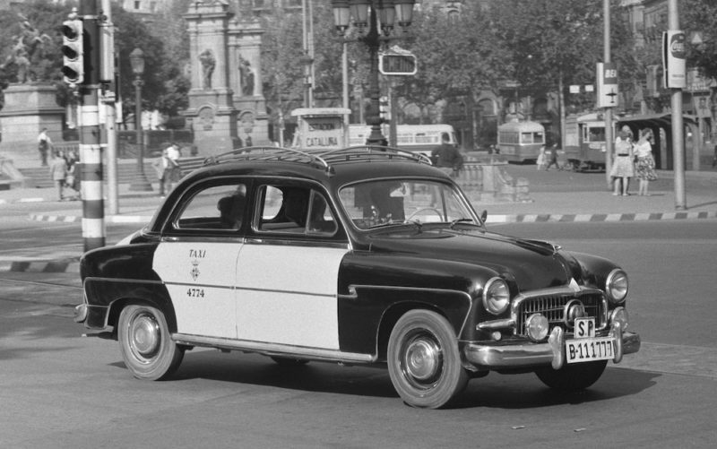 El Seat 1400 B era la versión española del Fiat 1400 / 1900, diseñado por Dante Giacosa gracias a los créditos del Plan Marshall. En la imagen, un 1400 B (con sus escasos 58 CV) haciendo las veces de taxi en Barcelona una soleada mañana de octubre de 1960. Fotografía de Harry Pot. National Archief. Imagen de dominio público.